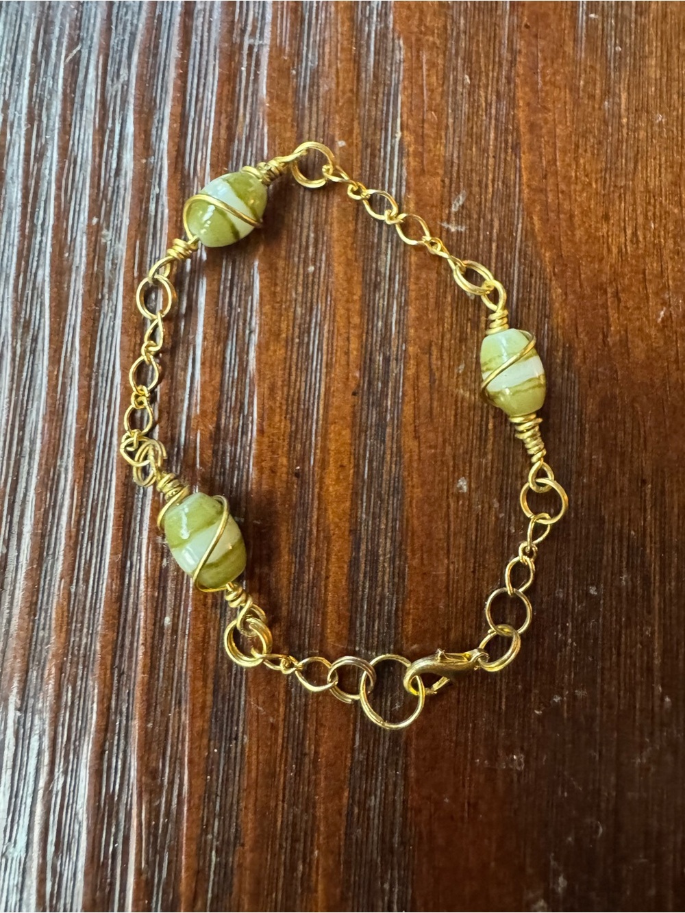 8" gold tone bracelet with green jade-tone beads. NWOT.
